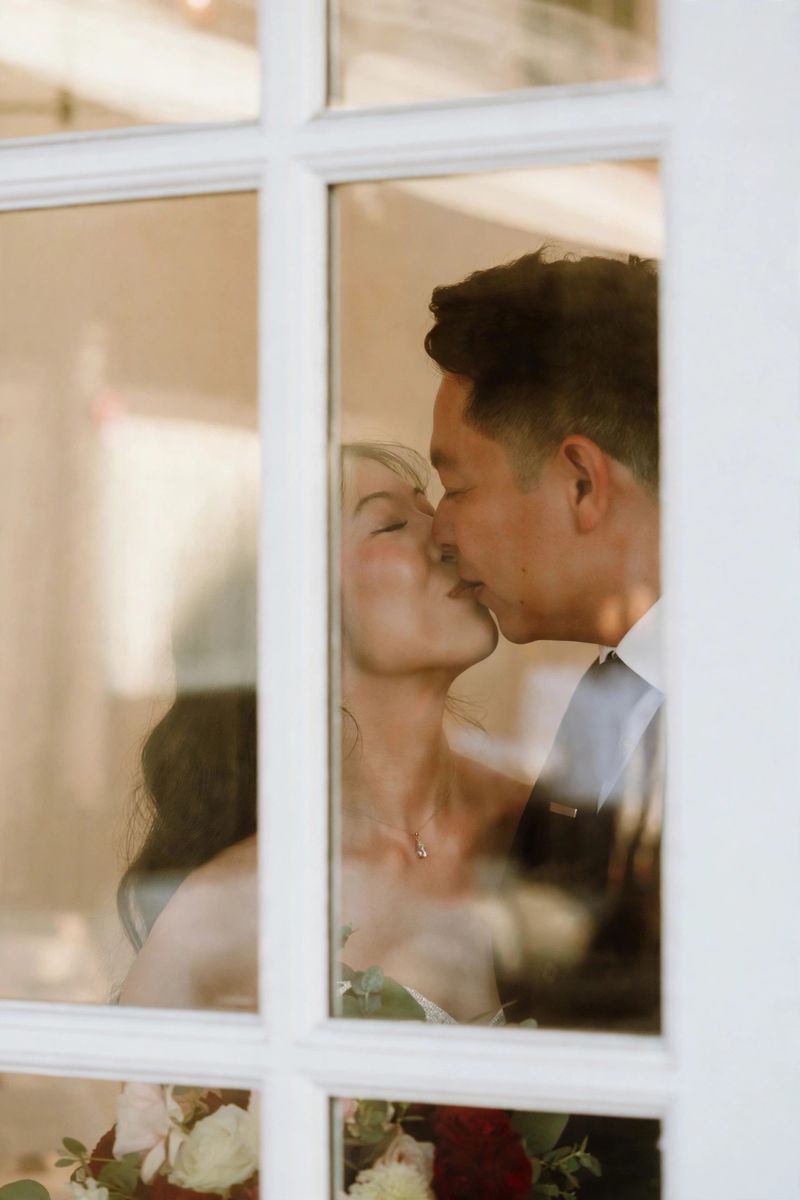 Jose and Taryn kissing, photographed through a window